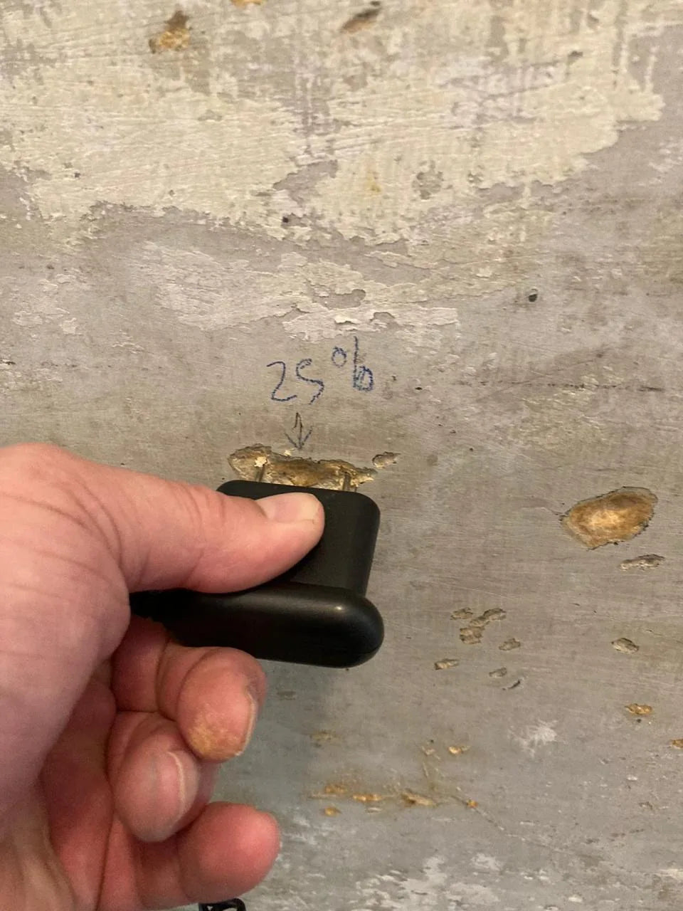 Plaster flaking away from the base of a damp wall