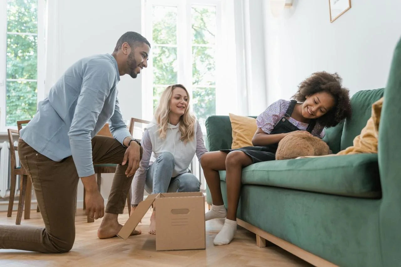A family relaxing together in their living room, one of them stroking a cat