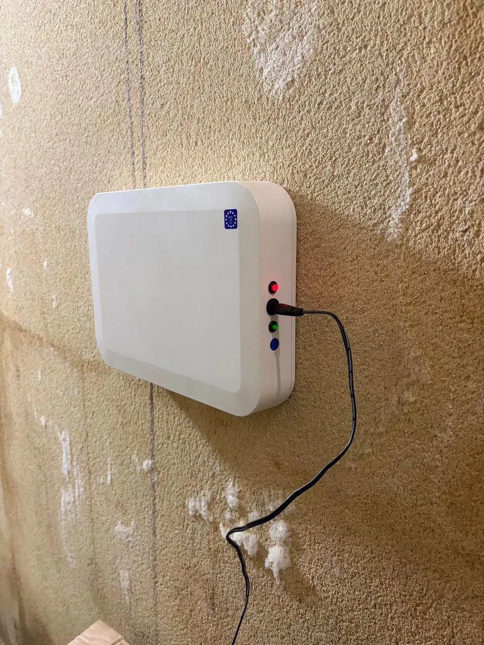 An RDbox screwed to a damp masonry wall, with salt efflorescence around it